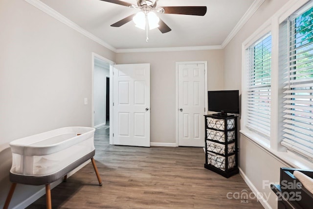 interior space with ornamental molding, ceiling fan, and dark hardwood / wood-style flooring