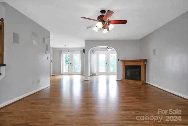 unfurnished living room featuring ceiling fan, french doors, and hardwood / wood-style flooring