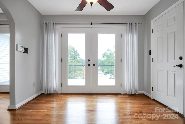 doorway with light hardwood / wood-style floors, ceiling fan, and french doors