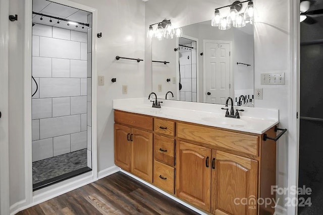 bathroom featuring a tile shower, vanity, and hardwood / wood-style flooring