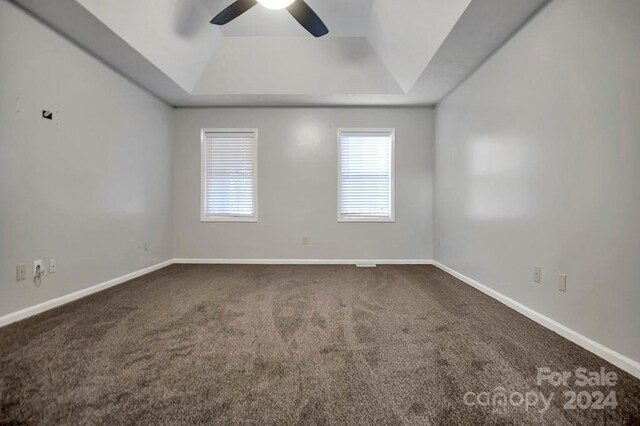 carpeted spare room with ceiling fan and a raised ceiling