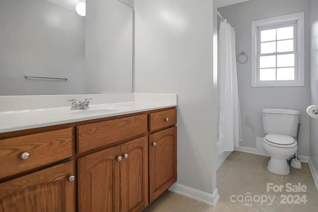 bathroom with tile patterned flooring, curtained shower, vanity, and toilet