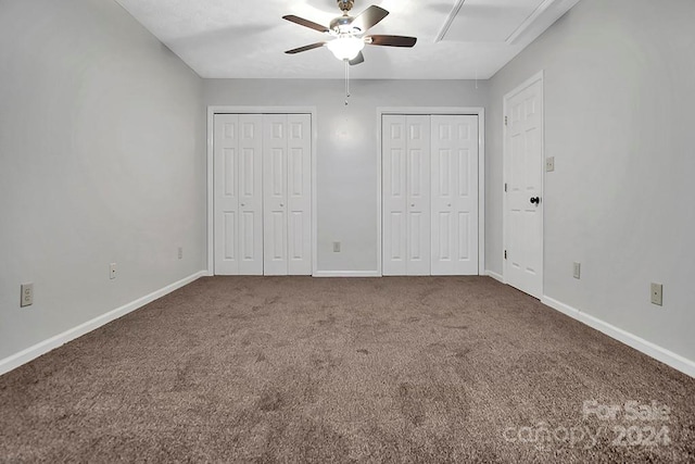 unfurnished bedroom with carpet floors, two closets, and ceiling fan