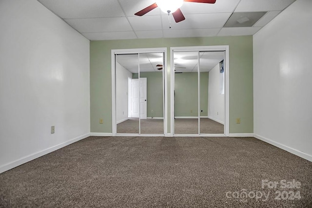 empty room featuring a drop ceiling, ceiling fan, and carpet flooring