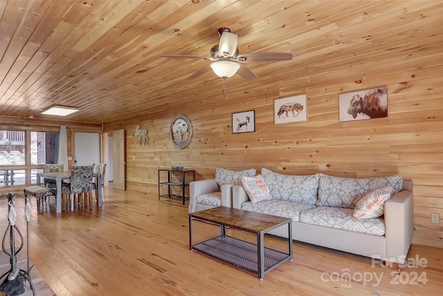 living room with ceiling fan, wood walls, wooden ceiling, and light hardwood / wood-style flooring