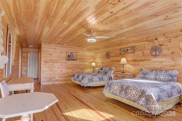 bedroom featuring ceiling fan, wood walls, light wood-type flooring, and wooden ceiling