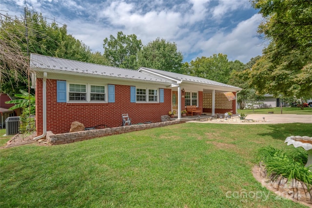 ranch-style home featuring cooling unit and a front lawn