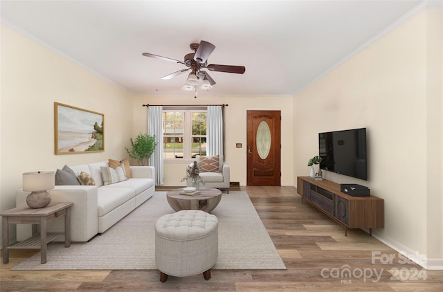 living room with ornamental molding, wood-type flooring, and ceiling fan