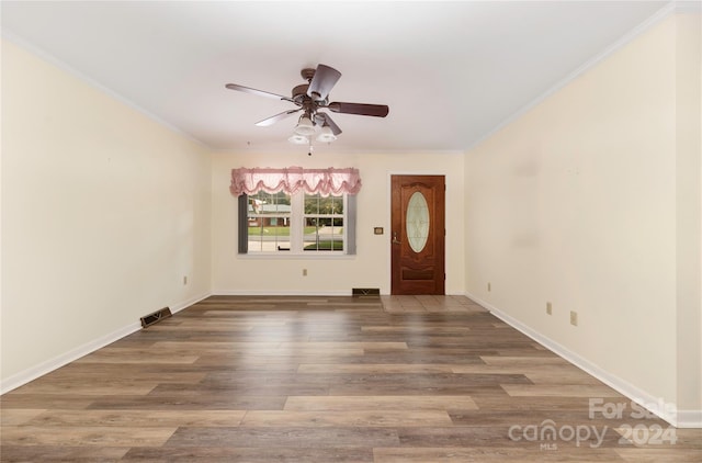 entrance foyer featuring wood-type flooring, ornamental molding, and ceiling fan