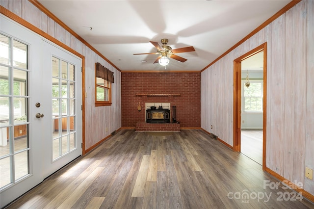 unfurnished living room featuring a fireplace, ornamental molding, ceiling fan, and hardwood / wood-style flooring