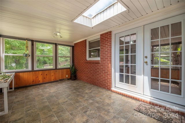 unfurnished sunroom featuring french doors, a skylight, and wood ceiling