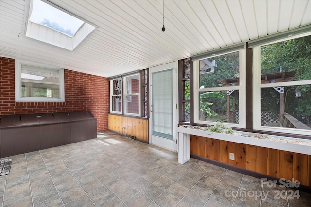 unfurnished sunroom featuring a skylight and wooden ceiling