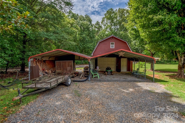 view of front of house featuring a carport and an outbuilding