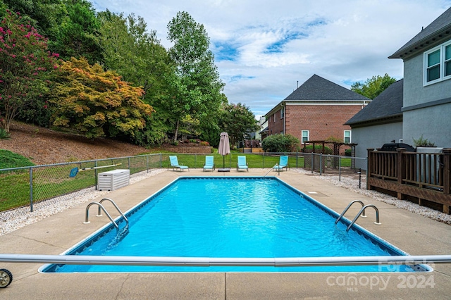 view of swimming pool with a patio area and a diving board