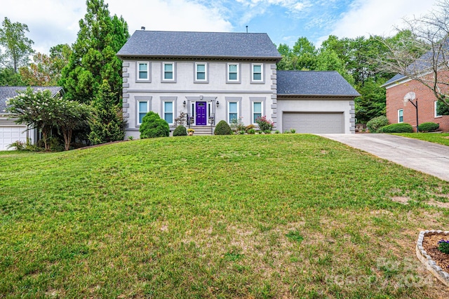 colonial house featuring a front lawn and a garage