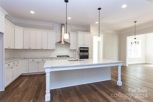 kitchen featuring dark hardwood / wood-style floors, wall chimney range hood, and white cabinets