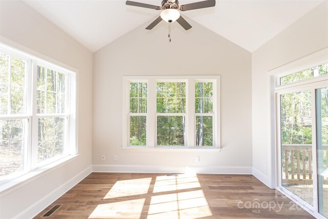 unfurnished sunroom featuring lofted ceiling, plenty of natural light, and ceiling fan