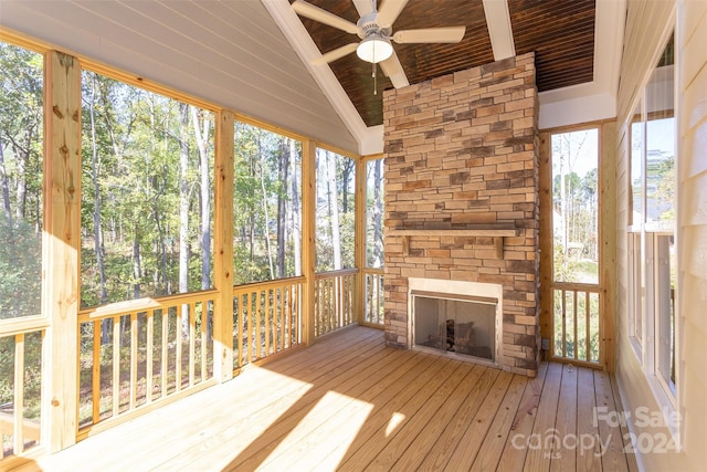 unfurnished sunroom featuring a wealth of natural light, ceiling fan, vaulted ceiling, and wooden ceiling