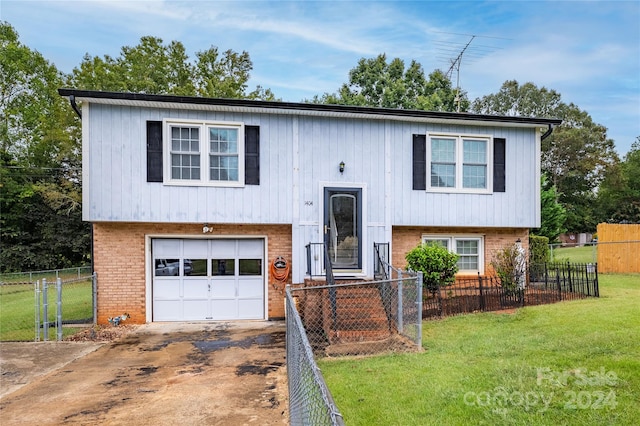 bi-level home featuring a garage and a front lawn