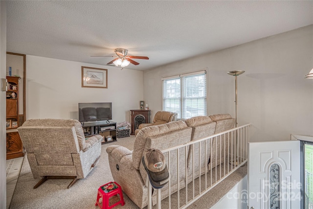 living room featuring ceiling fan and a textured ceiling