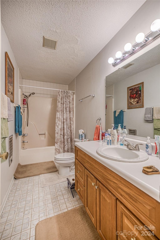 full bathroom featuring vanity, toilet, a textured ceiling, and shower / tub combo with curtain