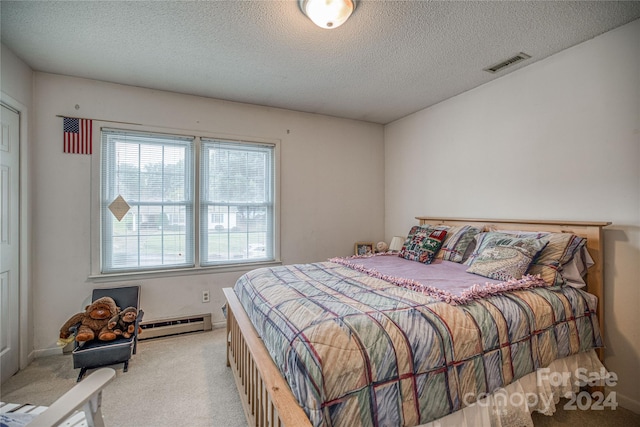 bedroom featuring light colored carpet, a textured ceiling, and a baseboard heating unit