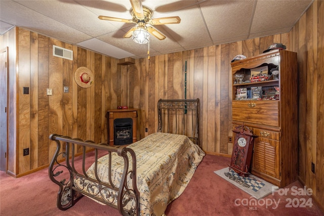 carpeted bedroom with wooden walls and ceiling fan