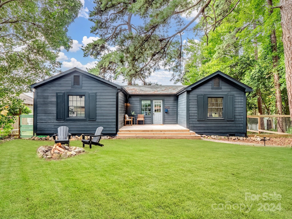 rear view of property with a yard and a wooden deck