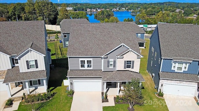 view of front of home featuring a garage, a front lawn, and a water view