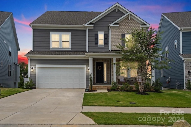 craftsman house with a garage and a lawn