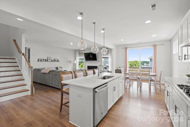 kitchen with white cabinets, an island with sink, appliances with stainless steel finishes, and sink