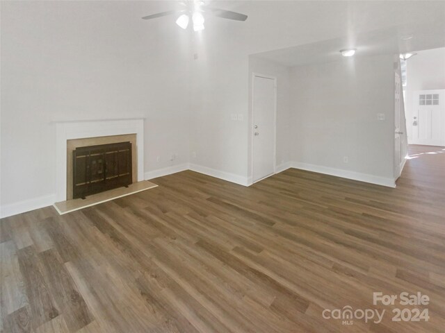 unfurnished living room with dark wood-type flooring and ceiling fan