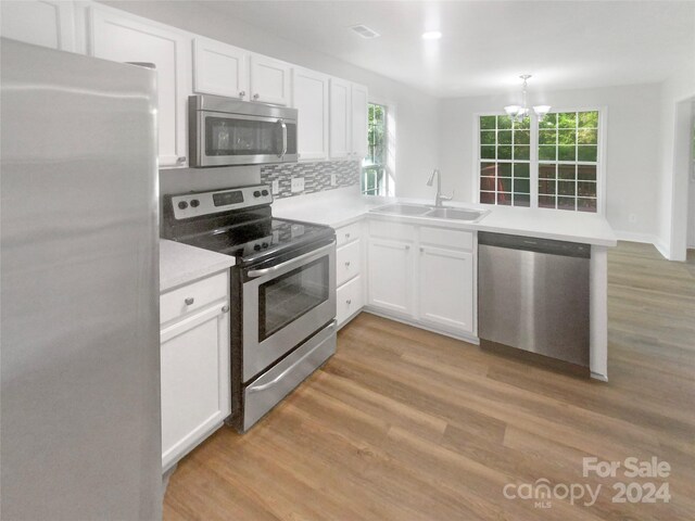 kitchen featuring a healthy amount of sunlight, stainless steel appliances, sink, and kitchen peninsula