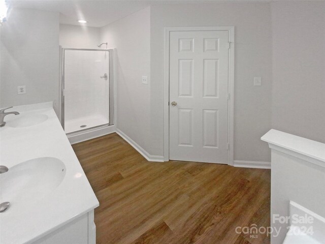 bathroom with wood-type flooring, an enclosed shower, and vanity