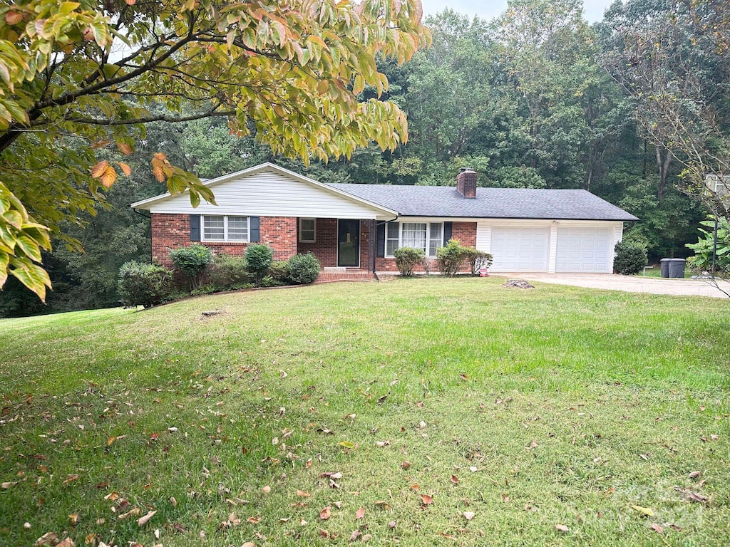 ranch-style house featuring a garage and a front lawn