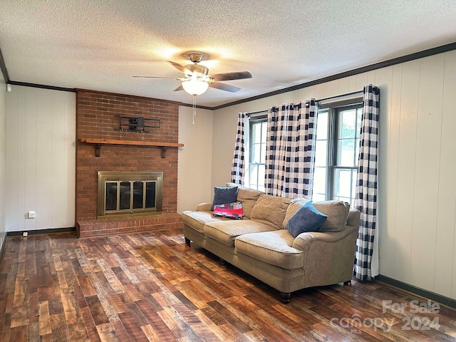 living room featuring ornamental molding, a fireplace, dark hardwood / wood-style floors, and a textured ceiling