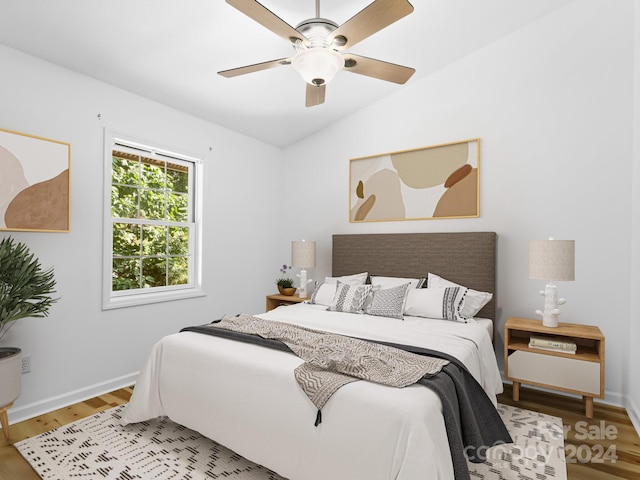 bedroom with light hardwood / wood-style flooring, ceiling fan, and vaulted ceiling