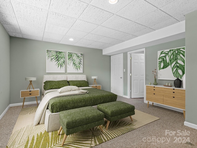 bedroom featuring carpet flooring and a drop ceiling