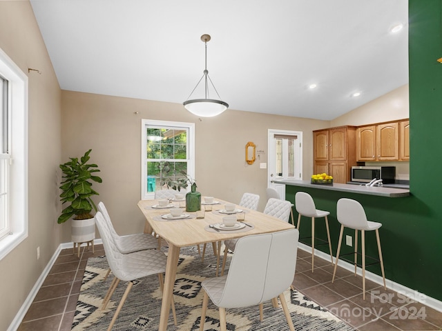 tiled dining area with lofted ceiling