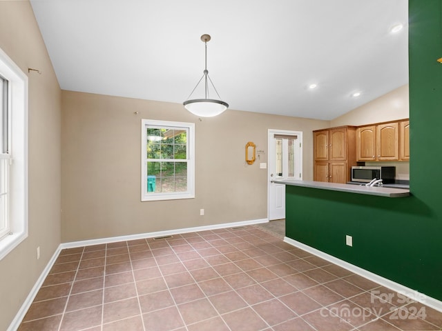 kitchen featuring lofted ceiling, pendant lighting, and light tile patterned floors