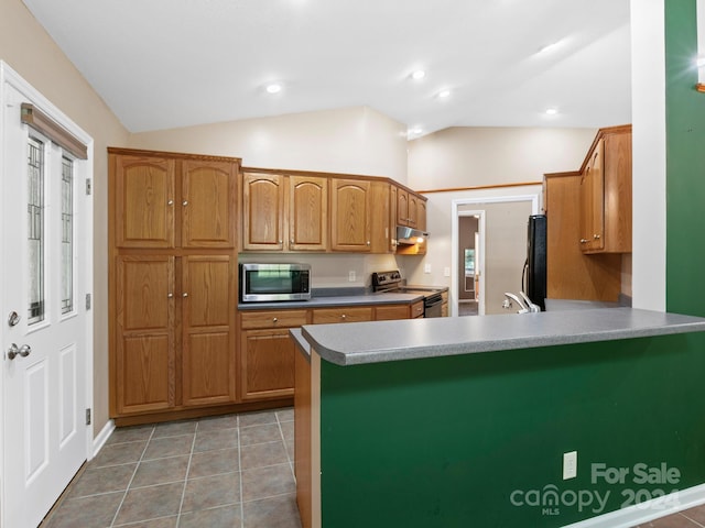 kitchen featuring light tile patterned floors, vaulted ceiling, kitchen peninsula, sink, and appliances with stainless steel finishes