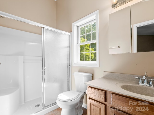 bathroom with vanity, toilet, tile patterned floors, and a shower with shower door