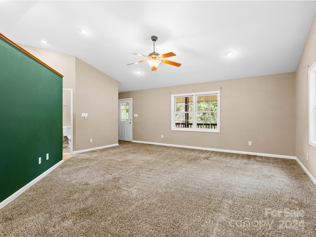 empty room with lofted ceiling, ceiling fan, and carpet