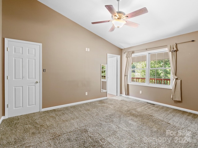 empty room with lofted ceiling, ceiling fan, and carpet