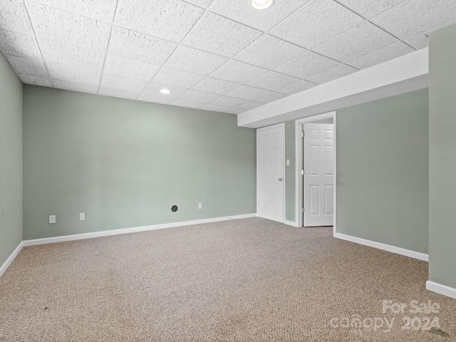 carpeted empty room with a paneled ceiling