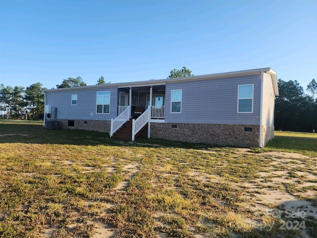 manufactured / mobile home featuring a front yard and central AC