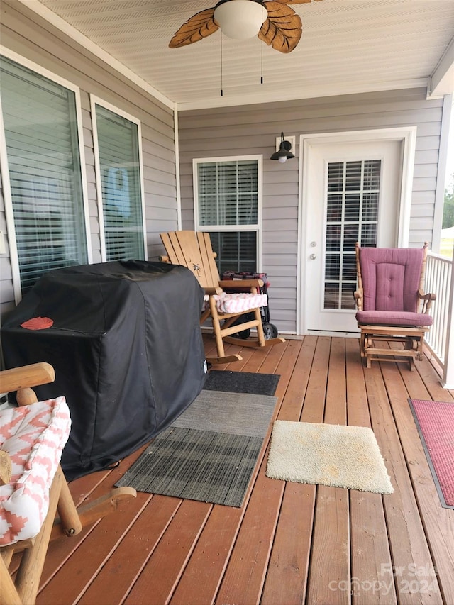 deck with covered porch, ceiling fan, and a grill