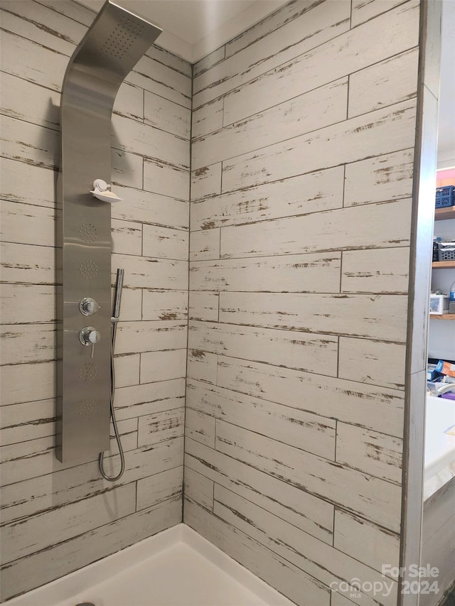 bathroom with a shower and wooden walls