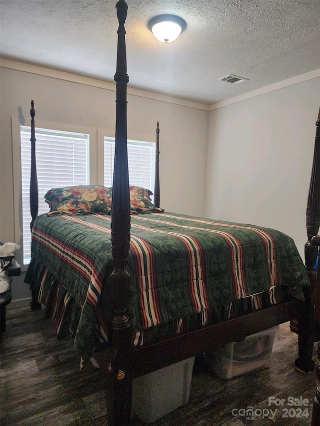 bedroom with hardwood / wood-style floors and a textured ceiling