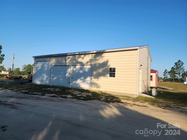 view of side of home with a garage and an outdoor structure